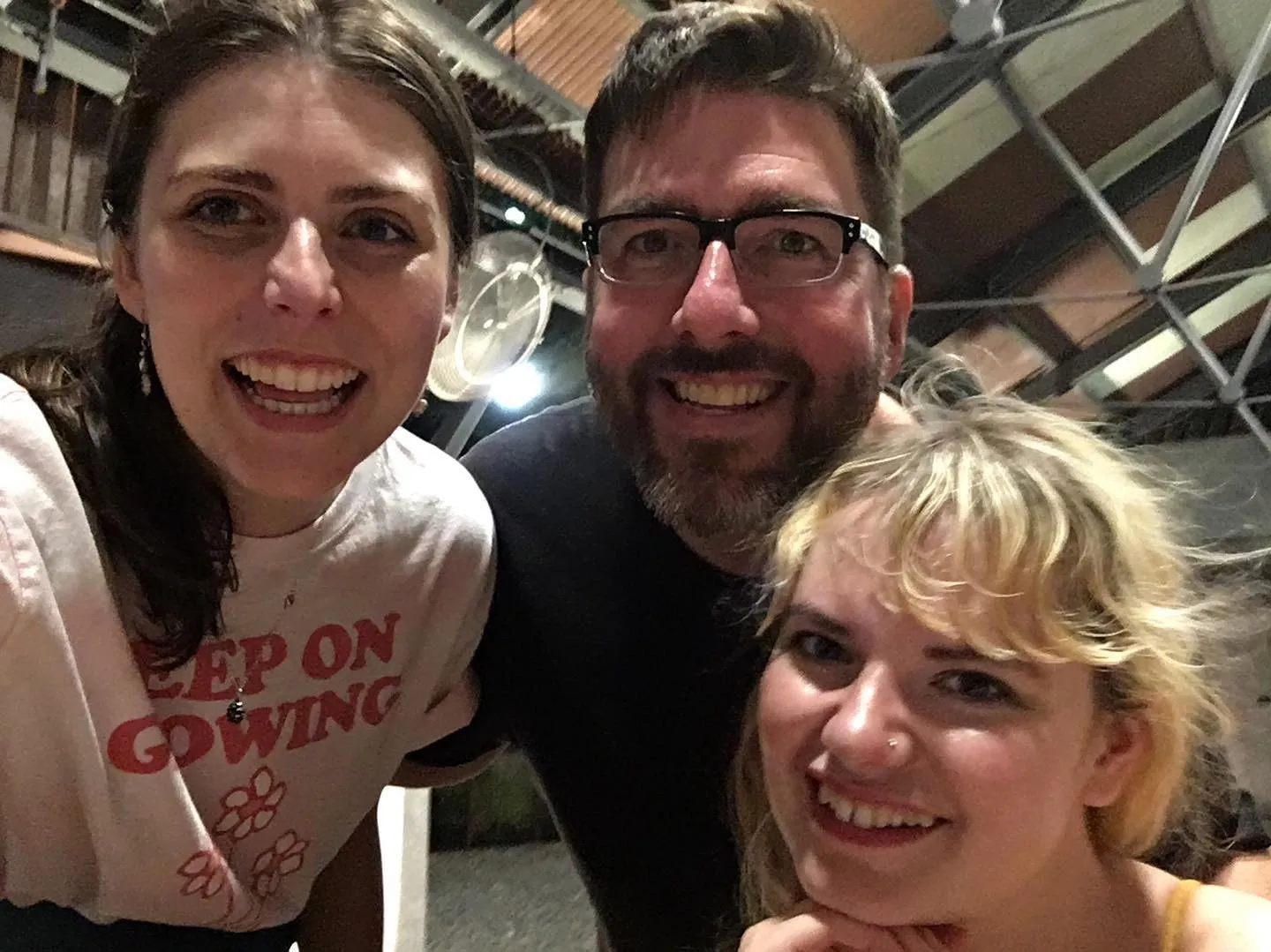 Hallie, Chris, and Catherine smiling at the camera and celebrating one year of podcasting